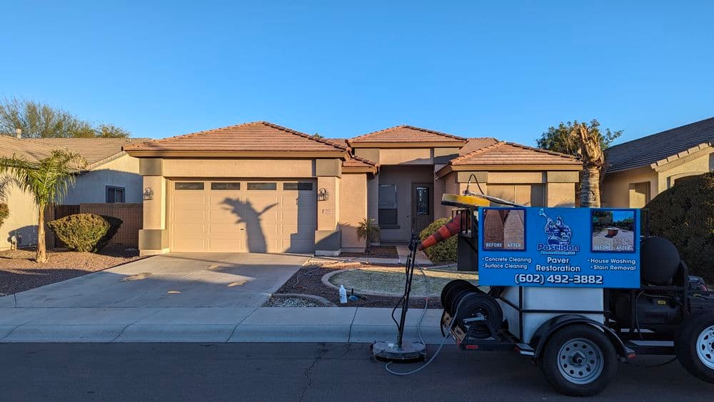 Power washing service vehicle in front of a modern home with desert landscaping.