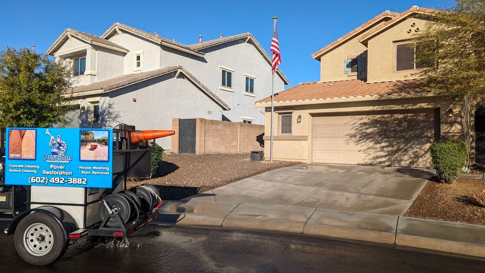 Concrete cleaning truck parked in front of residential homes with American flag.
