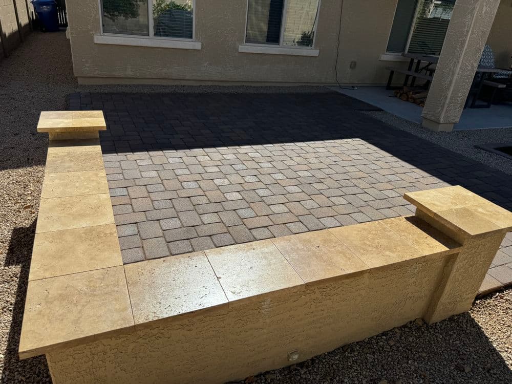Paver patio with surrounding decorative walls in a sunlit outdoor space.