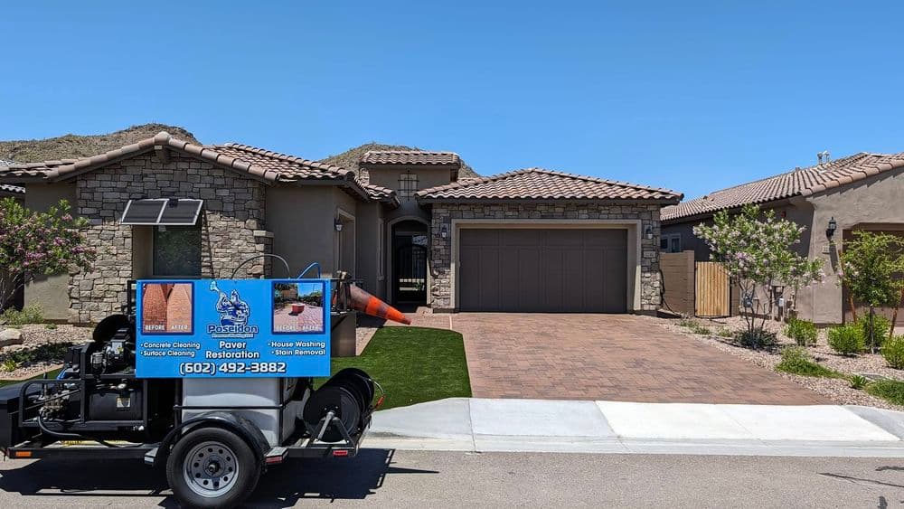 House exterior with power washing truck parked, featuring stone and stucco design.