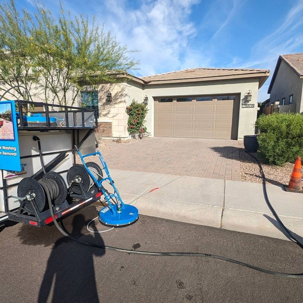 Pressure washing equipment in front of a home for driveway cleaning services.