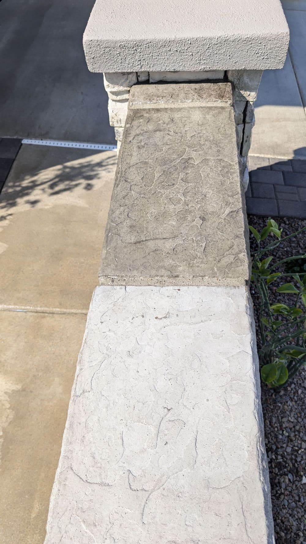 Textured concrete walkway with contrasting gray stones and smooth border.