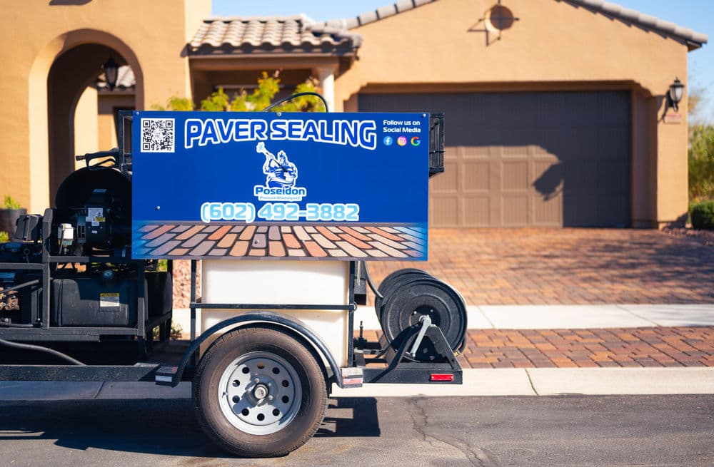 Paver sealing service truck with Poseidon branding and contact information in front of a home.